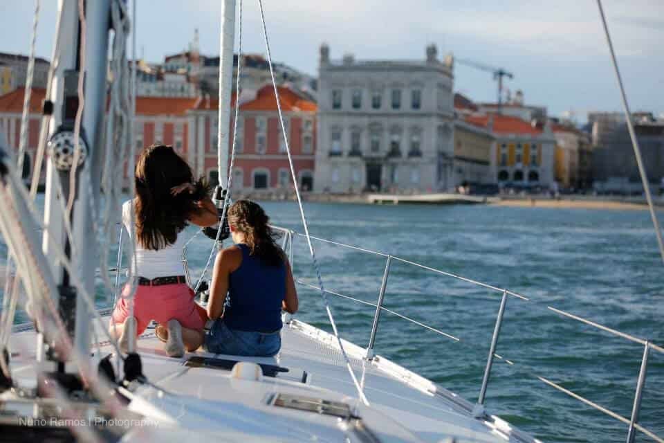 Two women on a sailboat contemplating Comnerce Square