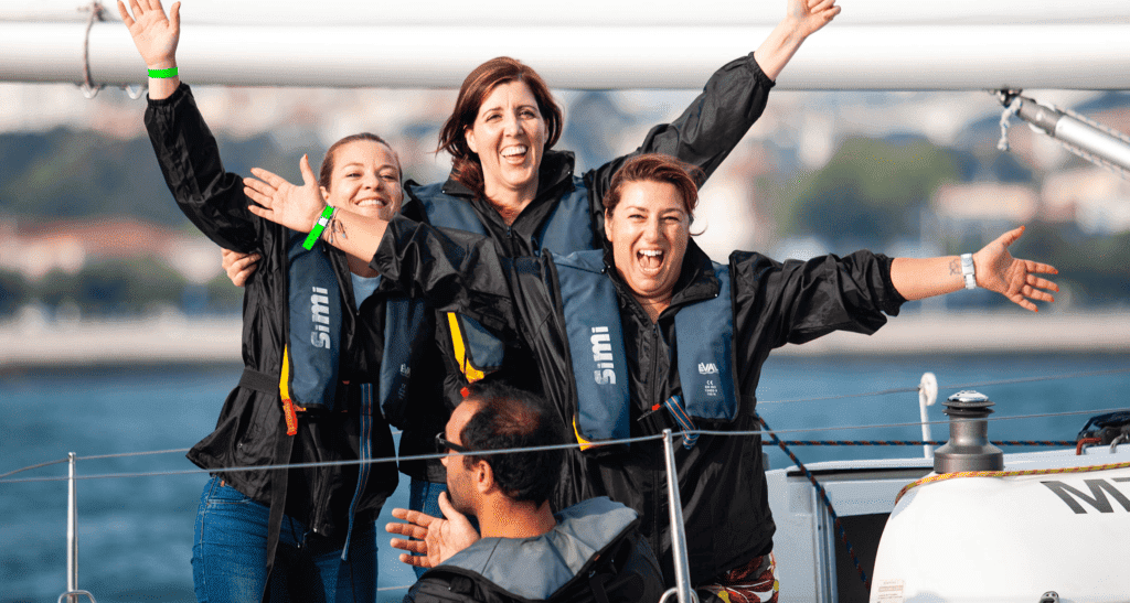 Três senhoras a celebrarem a vitória durante uma atividade de team-building no rio Tejo