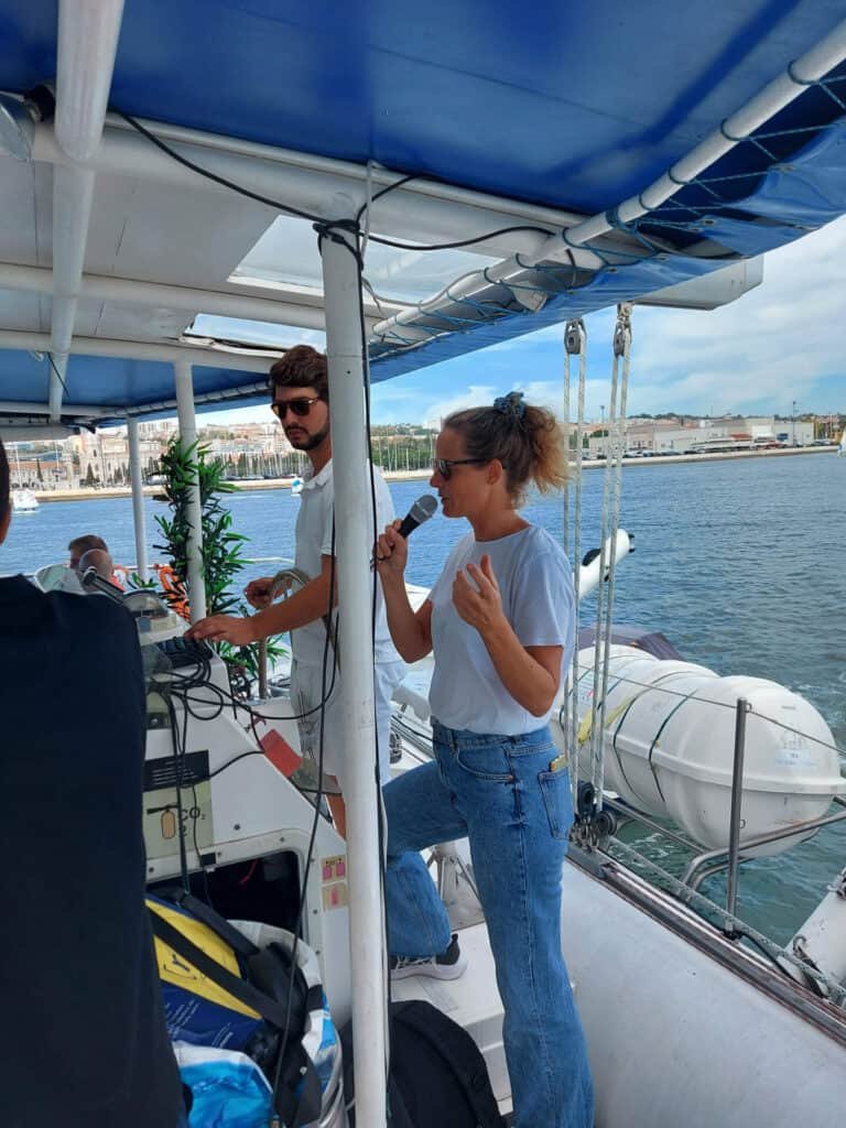 Guia turística a prestar explicações sobre Lisboa durante um passeio de barco