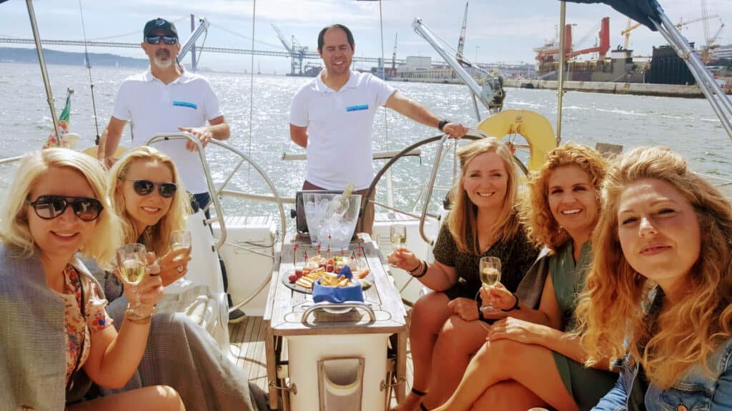 Grupo de amigas navegando en un velero en Lisboa y dos tripulantes
