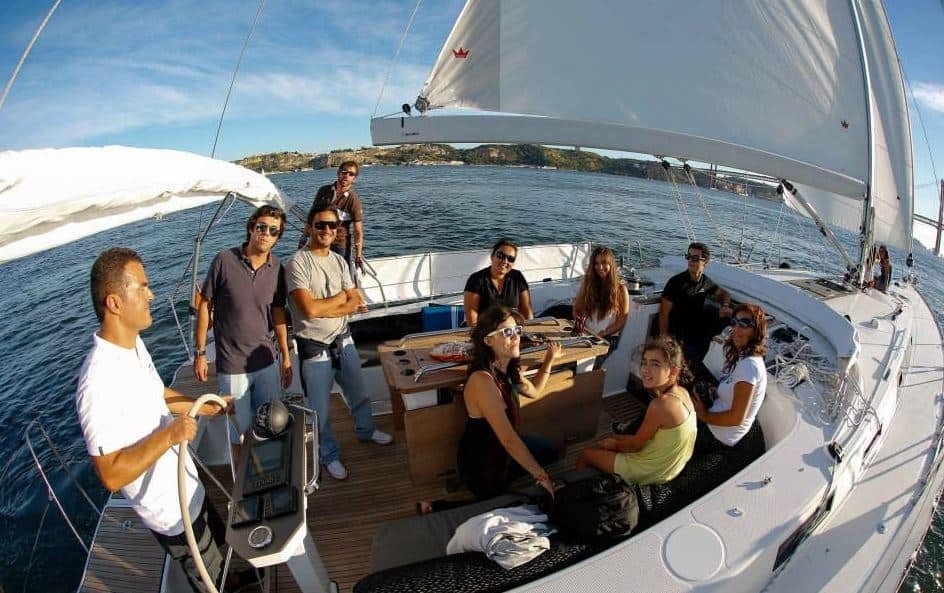 A group of friends cruising on a sailboat in Lisbon