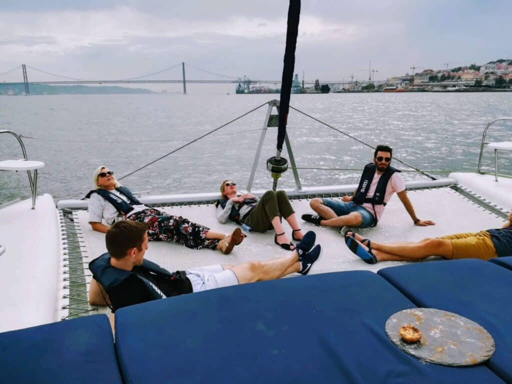 Gente relajándose tumbada en la hamaca del catamarán