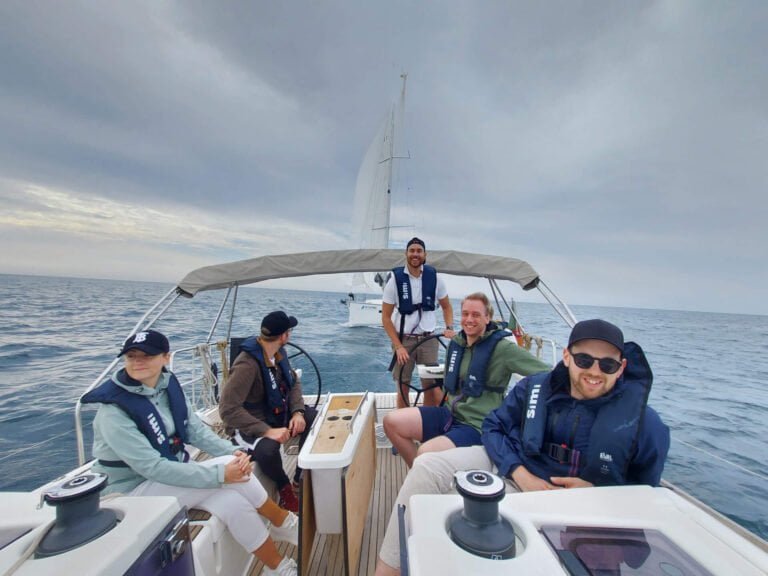 Team Building Events. People crewing a sailboat during a regatta in Cascais
