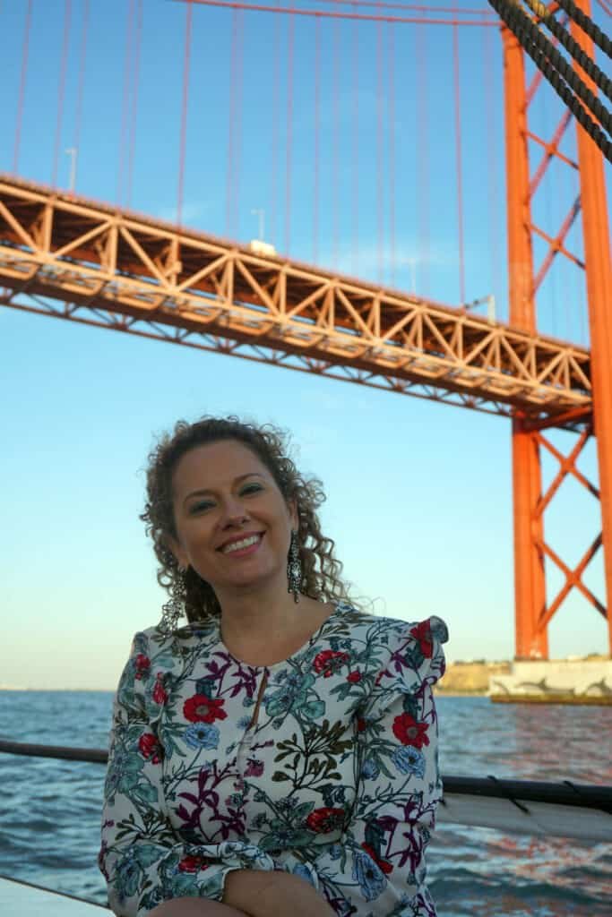 Events Team Building, woman on a sailboat passing under the bridge over the Tagus