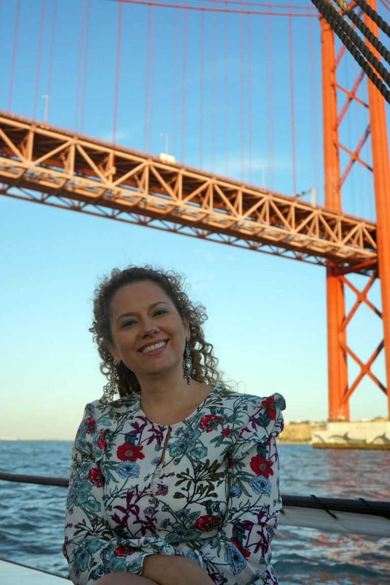 Team Building events, woman on a sailboat passing under the Tagus River Bridge
