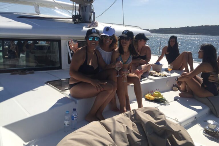 Jovens a divertirem-se na proa do catamaran