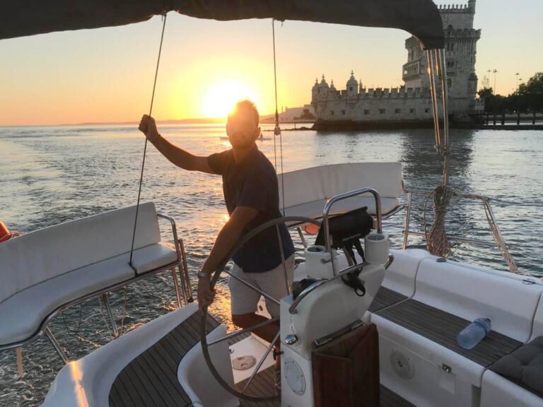 Patrón disfrutando del atardecer, con la Torre de Belém al fondo