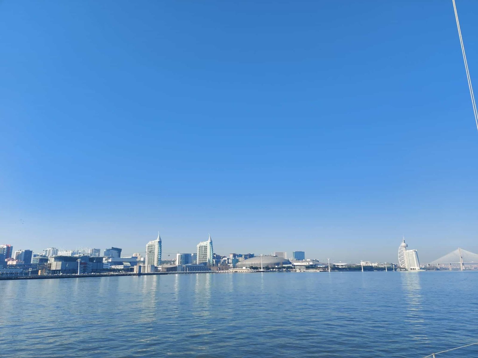 View of Nations' Park from the river. The Vasco da Gama Tower, the Vasco da Gama Bridge, the Atlantic Pavilion, and the Oceanarium can be identified