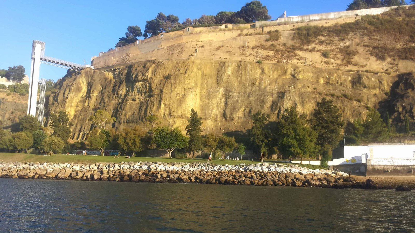 Garden with a cliff in the background and panoramic elevator seen from the Tagus River