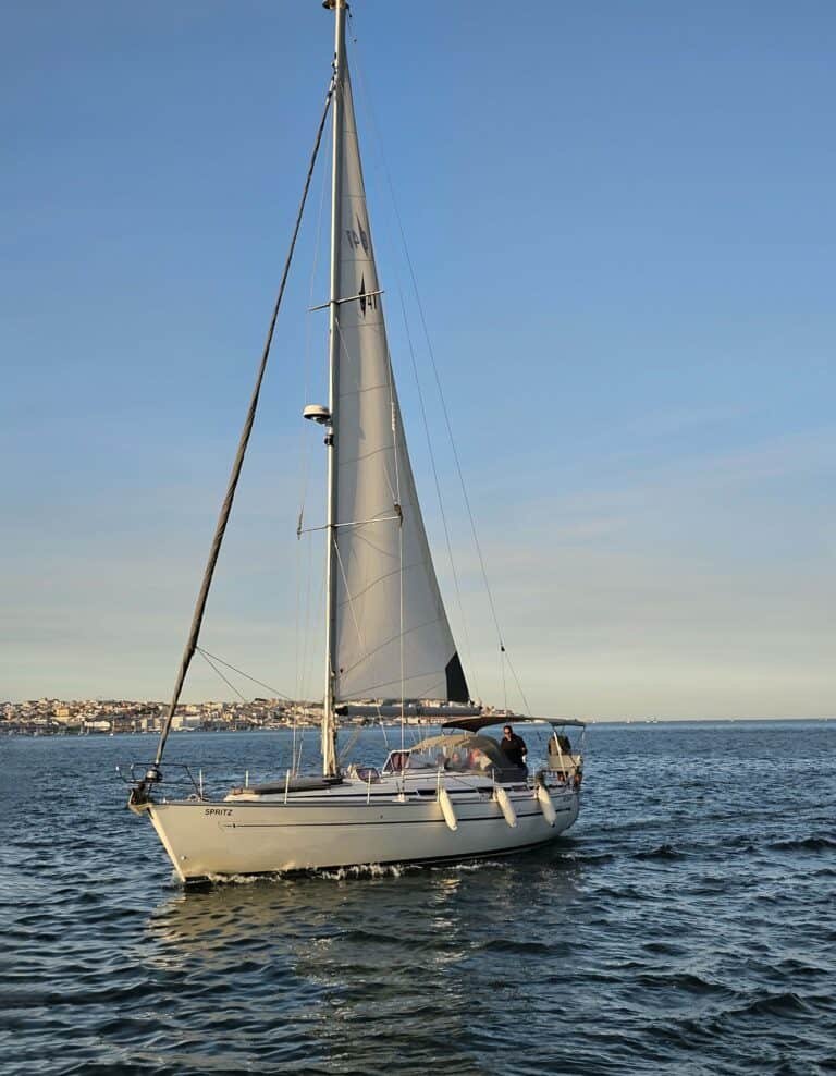 Magnífico velero navegando hacia la puesta de sol, disfrutando de impresionantes vistas de las orillas del río Tajo