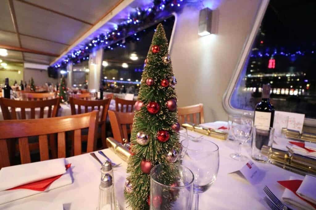Jantar de natal a bordo. Mesa decorada com uma mini árvore de natal. Com vista para o rio
