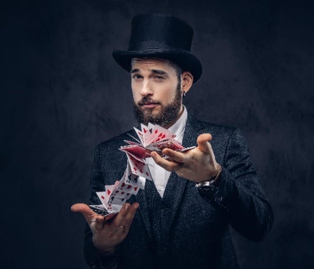 Um mágico com as suas cartas, pronto para fazer um truque de magia e entreter o público