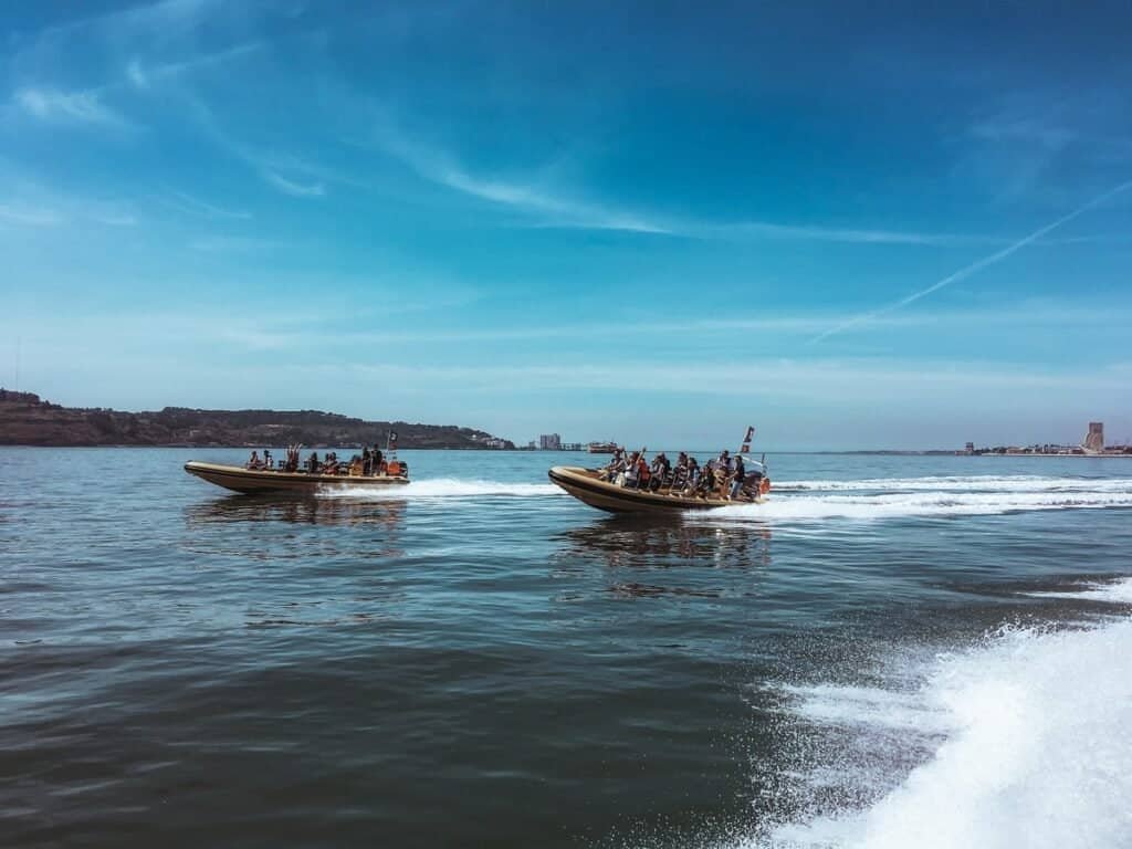 Os speedboats transportam um grupo de pessoas no rio Tejo