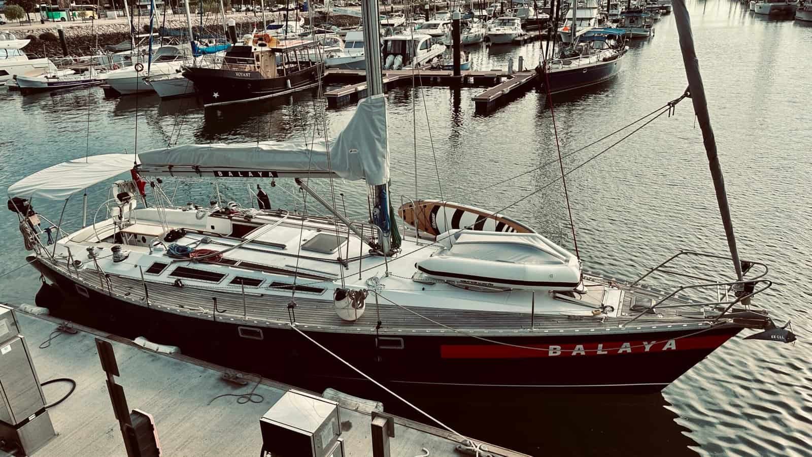 Sailboat moored at the dock, with a SUP board on board