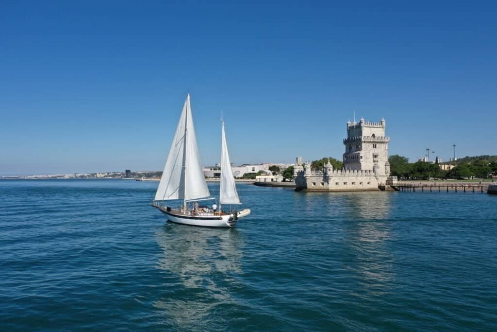 47-foot sailboat cruising down the Tagus River on a beautiful sunny day