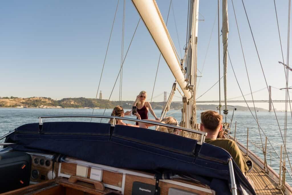 A group of tourists enjoying the beautiful views from the Tagus River, during a peaceful cruise with little swell