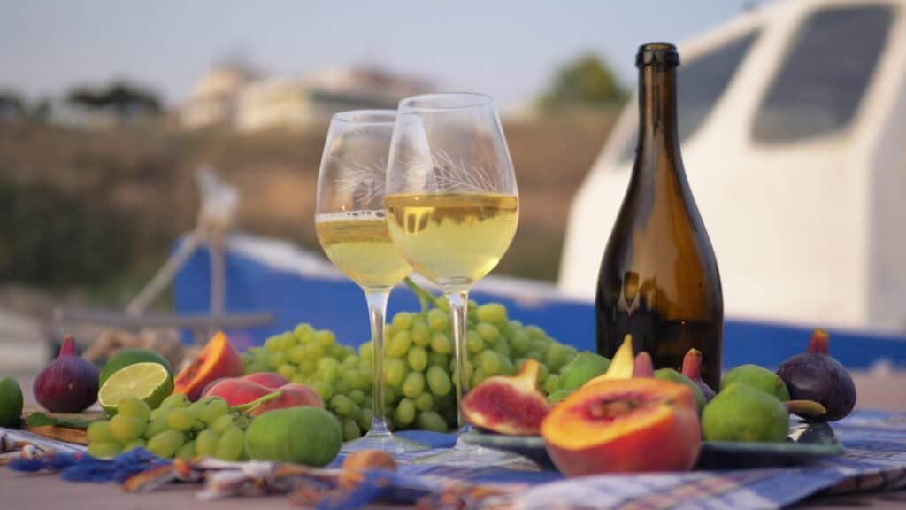 Tomar vino y fruta fresca junto al mar