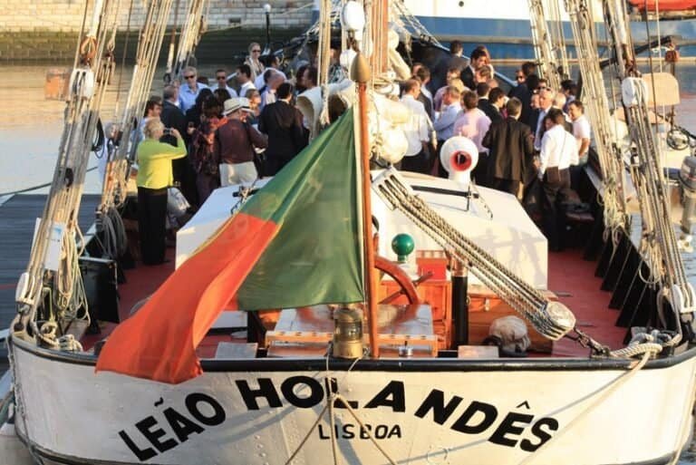 O navio está decorado para um evento, com um grupo reunido na parte traseira.