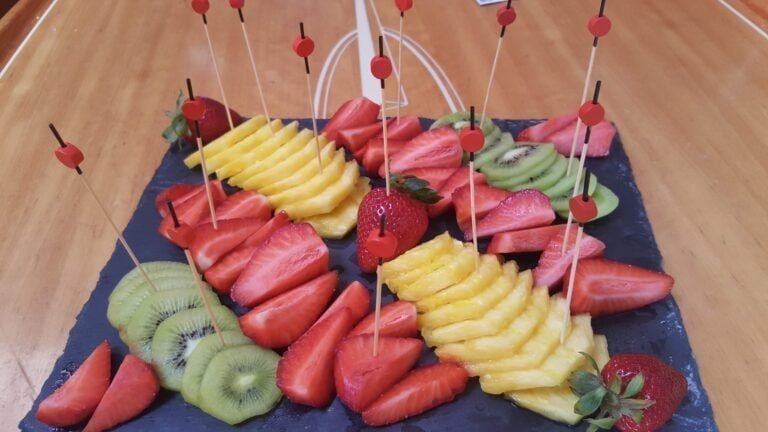 Presentation of platters with assorted fruits like kiwi, strawberries, and pineapple