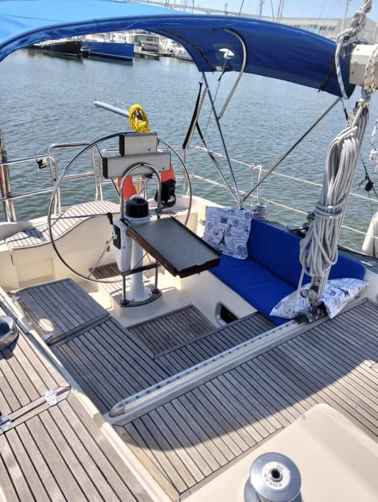 Navigation area equipped with helm, padded bench seats, and canopy for greater comfort on board