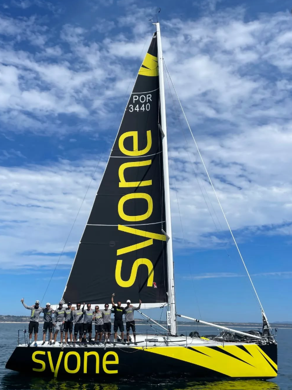 The Syone Sailing Team boat in action, highlighting the large mainsail with the Syone logo.