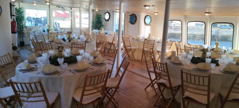 The main salon decorated with round tables, white tablecloths, and classic chairs, showing the ship's capacity for formal dinners.