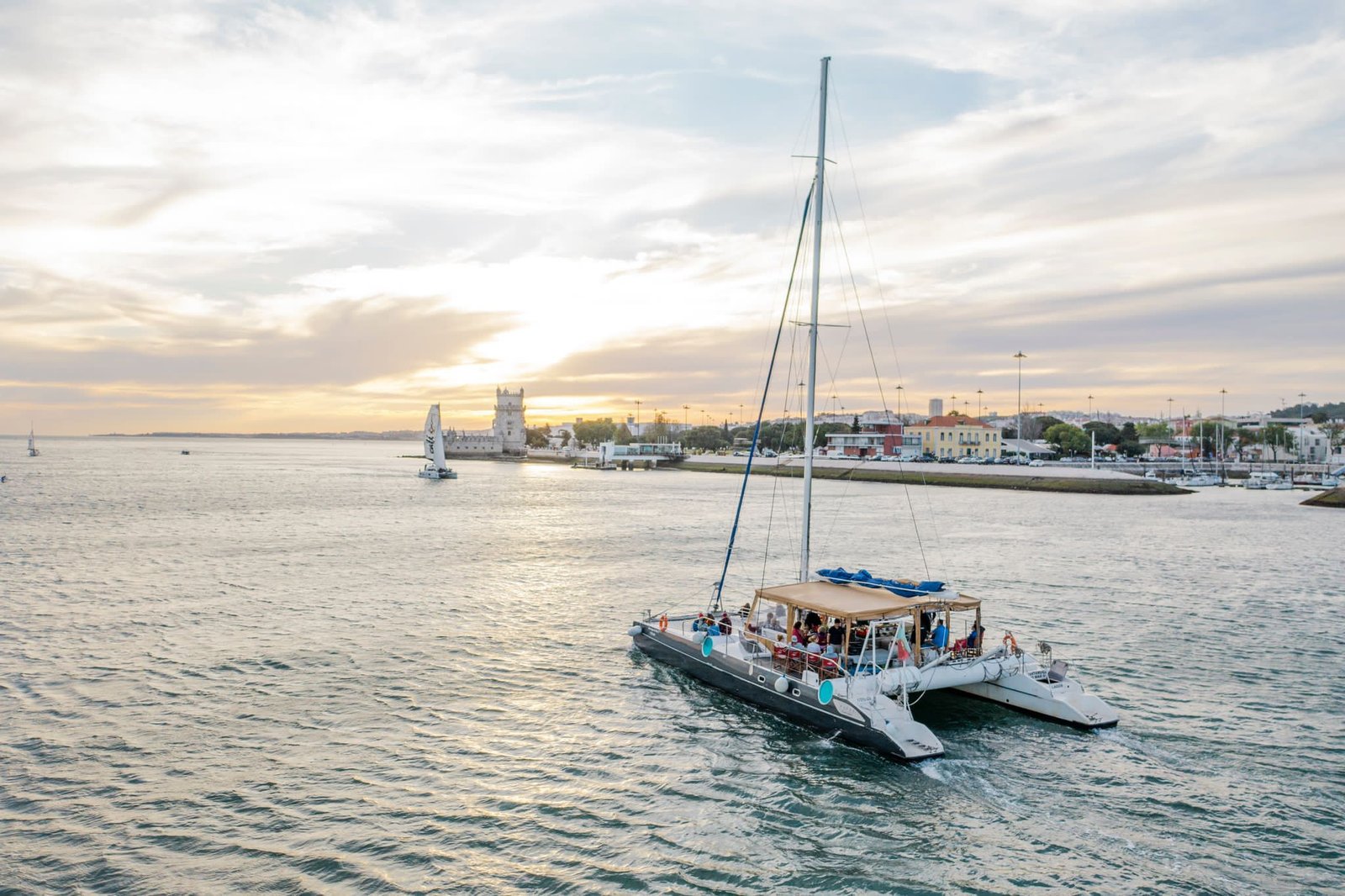 O barco, um Taiti 60 branco de grandes dimensões, destaca-se contra o céu do fim de tarde
