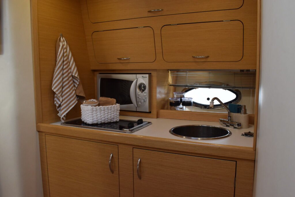Cocina equipada en el interior del yate Maggiore con acabados en madera clara.