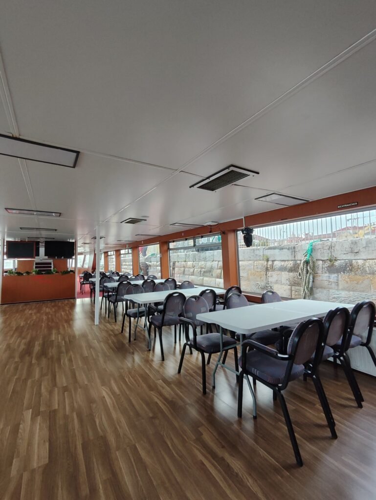 Interior do deck inferior com piso de madeira, proporcionando um espaço amplo e funcional para logística de eventos.