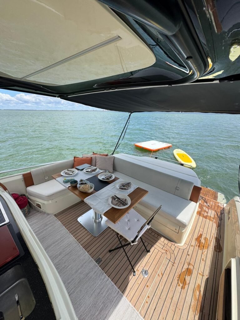 Perspetiva ampla do convés do iate Invictus GT370, realçando o design premium, o conforto das áreas espaçosas e o acesso direto às águas do Tejo.