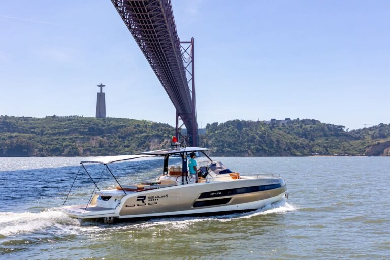 Iate Invictus GT370 a navegar sob a Ponte 25 de Abril em Lisboa durante passeio de barco.