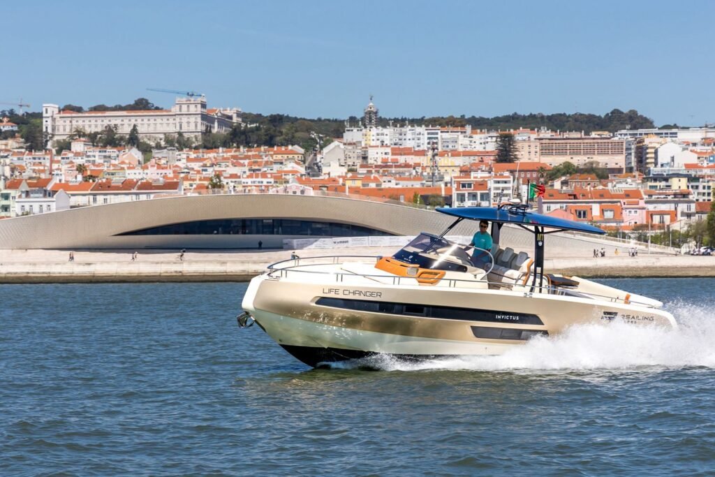 Luxury Invictus GT370 yacht sailing in front of MAAT and Lisbon’s waterfront area.