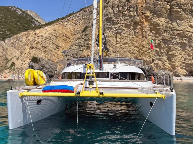 Catamarán fondeado junto a una playa cerca de Sesimbra
