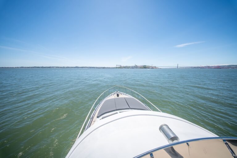 On voit la proue du yacht naviguant sur des eaux calmes sous un ciel dégagé.