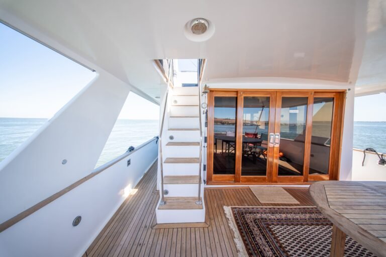 L'escalier menant au flybridge et les baies vitrées coulissantes donnent sur le salon intérieur