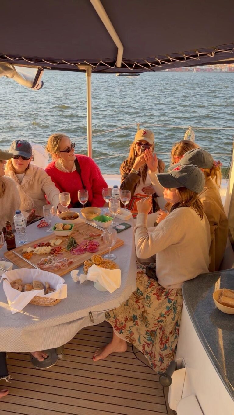 Grupo de amigos reunido à mesa exterior do catamarã Corto Maltese III, a desfrutar de uma refeição partilhada a bordo, com vista para o rio Tejo. Experiência gastronómica no mar em Lisboa, ideal para almoços ou jantares em catamarã, celebrações em grupo e eventos privados com serviço de catering a bordo.