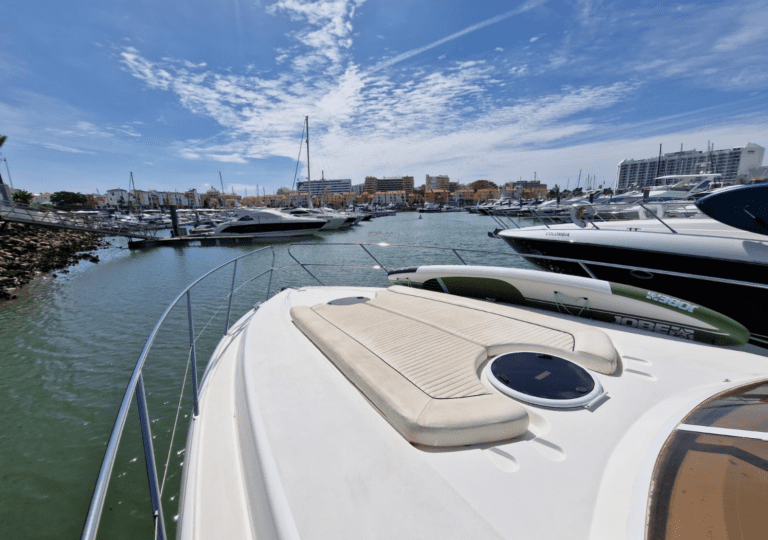Vue depuis la proue du Doris of Rock lors de sa sortie de la marina de Vilamoura, entouré d'autres bateaux et avec le paysage maritime de l'Algarve en toile de fond. Location d'un yacht à moteur Princess V42 à Vilamoura, idéal pour explorer la côte de l'Algarve dans le confort et l'élégance.