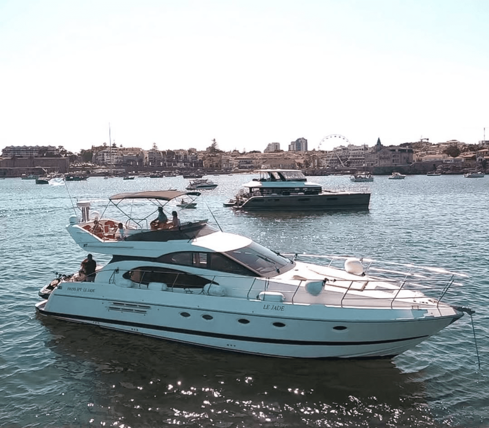 Luxury yacht Azimut 52 Le Jade sailing on the Tagus River with a view of the Cascais coast.
