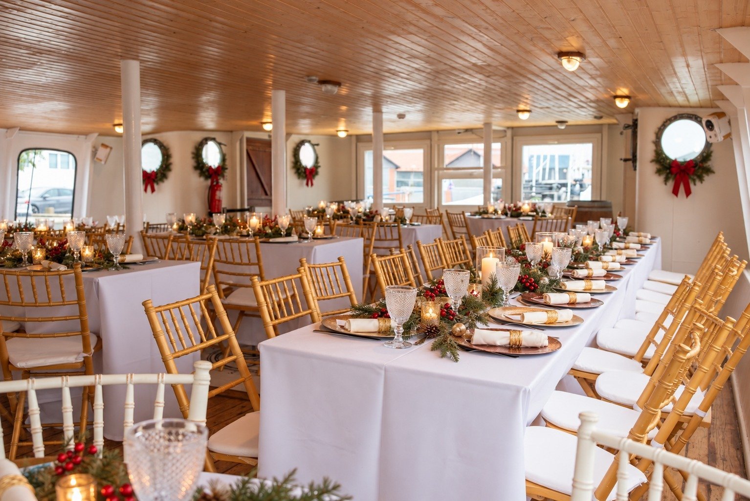 Espaço a bordo preparado para uma celebração de Natal em grupo, com mesas decoradas, iluminação acolhedora e ambiente festivo. Uma alternativa original para organizar um jantar de Natal de empresa ou evento privado num barco em Lisboa.